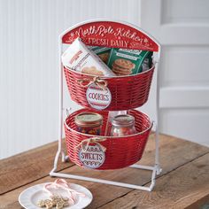 two red baskets filled with food sitting on top of a wooden table next to a plate