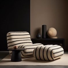 a black and white striped chair sitting on top of a rug next to a table