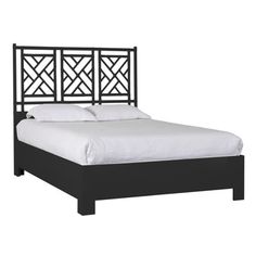 a black bed frame with white sheets and pillows