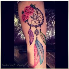 a woman's leg with a watercolor dream catcher and roses tattoo on it