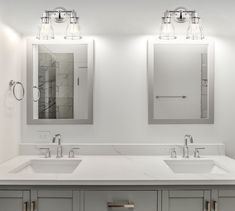 two sinks and mirrors in a white bathroom