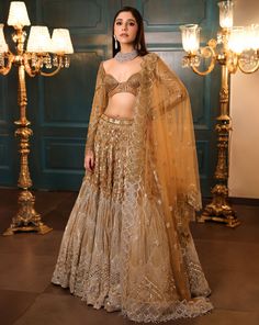 Ombre gold and silver bridal lehenga embellished with sequin, crystals, beads, cutdana embroidery, and a matching full-sleeved blouse in gold. The lehenga comes with a shaded embroidered cutwork dupatta.DELIVERY TIMEPlease allow 8-12 weeks for your outfit to arrive.FABRIC DETAILSNetProfessional cleaning only. Elegant Designer Lehenga With Gold Embroidery, Elegant Semi-stitched Choli With Gold Embroidery, Gold Bollywood Designer Lehenga, Bollywood Style Designer Gold Lehenga, Gold Embellished Lehenga For Reception, Gold Embellished Choli, Gold Floor-length Lehenga With Intricate Embroidery, Gold Lehenga With Intricate Embroidery Floor-length, Traditional Gold Sets With Mirror Work