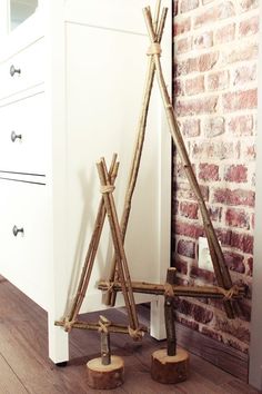 a white dresser sitting in front of a brick wall next to a tall wooden pole