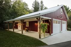 a red barn with a white roof and two garages