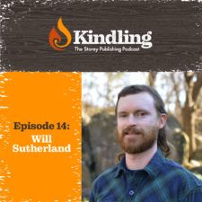 a man with long hair and beard standing in front of an orange sign that says kindling