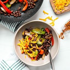 a bowl filled with beans, peppers and cheese