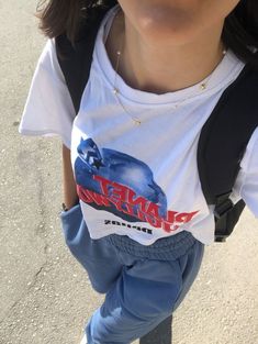 a person wearing blue pants and a white t - shirt with the word planet express on it