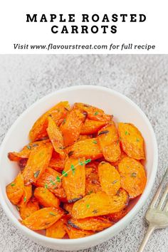 a white bowl filled with roasted carrots next to a fork