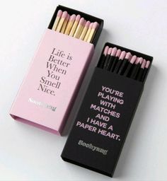 two matches are in a pink box and one is black with white writing on it