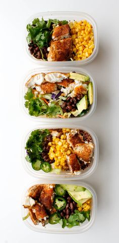 three plastic containers filled with food on top of a white table next to each other