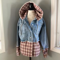 Perfect For Fall And Winter. This Jean Jacket Has Been Cut And Shows Exposed Raw Hems At The Sleeves And On The Body. Seen In Is A Brown Red And Blue Flannel Material That Looks Like The Jacket Is Fitting Over A Flannel Shirt. The Hood Is Removable. Silvertone Buttons, And Large Front Patch Pockets. Upcycled Hoodies, Marvel Jacket, Hooded Jean Jackets, Faux Fur Hoodie, Embellished Denim Jacket, White Jean Jacket, Green Utility Jacket, Olive Green Jacket, Hooded Denim Jacket