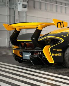 a yellow and black sports car is parked in a parking garage with its doors open