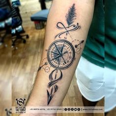 a person with a compass tattoo on their arm and an arrow in the other hand