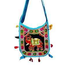 This eye-catching sling bag features a bold and colorful bohemian design, perfect for adding a touch of eclectic charm to any outfit. The central motif is a beautifully embroidered elephant, set against a black background and surrounded by an intricate border of geometric patterns and floral designs in red, green, white, and yellow hues. The bag's edges are adorned with playful blue trim and small red tassels that add movement and texture. With its ample size and lightweight feel, this crossbody purse is both practical and stylish, making it an ideal accessory for festivals, markets, or everyday adventures. Festive Bohemian Shoulder Bag With Motifs, Bohemian Embroidered Handheld Bag, Red Embroidered Bohemian Shoulder Bag, Bohemian Hand-stitched Crossbody Shoulder Bag, Travel-ready Multicolor Embroidered Hobo Shoulder Bag, Bohemian Elephant, Elephant Bag, Embroidered Elephant, Bohemian Bags