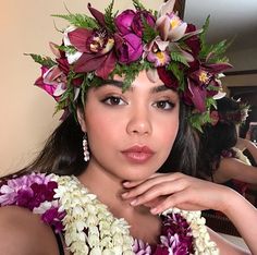 a woman with flowers in her hair posing for the camera while wearing a flower crown