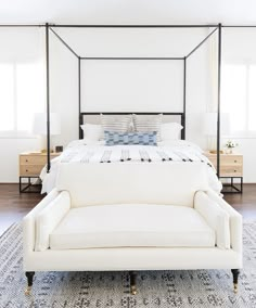 a white bed sitting on top of a wooden floor