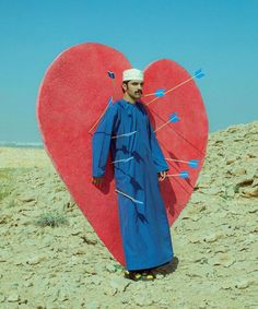 a man standing in front of a heart shaped object