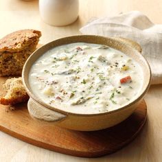 a bowl of soup on a wooden cutting board