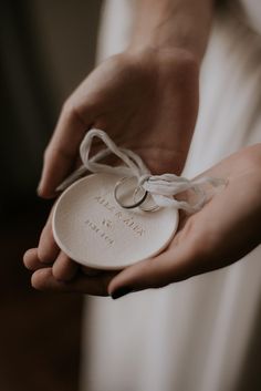 a close up of a person holding a ring in their hand with a tag on it