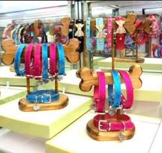 several different colored dog collars are on display in a store window with wooden stands