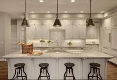 a kitchen with an island and four stools in front of the countertop area