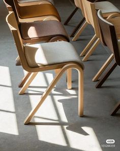 a row of wooden chairs sitting next to each other on top of a cement floor