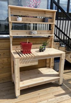 a potted plant on top of a wooden table next to a stair case and railing