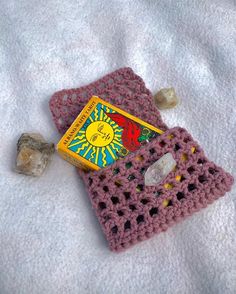 a crocheted book and rock on a blanket