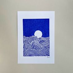 a blue and white paper cut with waves on it, under a full moon in the sky