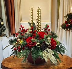 a christmas centerpiece with red roses and greenery