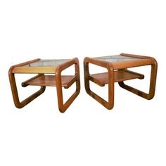 a pair of wooden tables with glass top on each side and one shelf in the middle