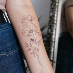 a woman's arm with a flower tattoo on the left side of her arm