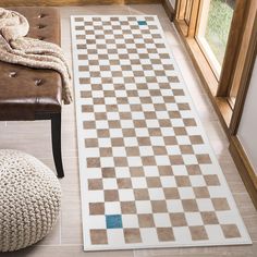 a brown and white rug sitting on top of a wooden floor next to a window