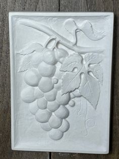 a white ceramic tile with grapes on it