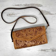 With its luxurious hand-embossed leather and stitched border detail, the Itzel Natural Leather Crossbody Bag by Que Chula is the perfect way to add a touch of bold style to any outfit. Securely store your essentials with the convenient credit card slots and exterior pocket, then let this daring design take you from day to night. Wow! Hand embossed genuine full grain leather Removable shoulder strap 8 Credit card slots 1 interior slip pocket 1 exterior zip pocket 9.5” x 5” x 2” Leather Shoulder Bag With Card Slots, Luxury Brown Shoulder Bag With Card Slots, Leather Wallet With Cell Phone Pocket, Leather Clutch With Cell Phone Pocket For Travel, Leather Clutch Phone Bag With Adjustable Strap, Leather Travel Clutch With Cell Phone Pocket, Leather Wallet On Chain With Mobile Phone Bag, Formal Leather Wallet With Cell Phone Pocket, Leather Satchel Shoulder Bag With Card Slots