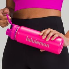 a woman holding a pink water bottle in her right hand