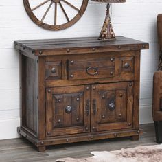 an old wooden cabinet with a lamp on top