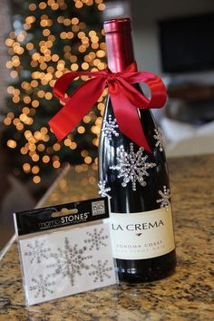 a bottle of wine sitting on top of a counter next to a card and christmas tree