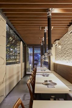 an empty restaurant with long tables and chairs