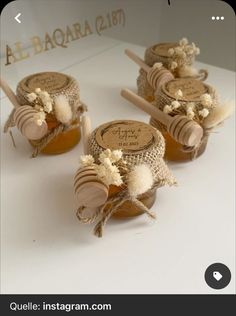 three honey jars with labels on them sitting on a table