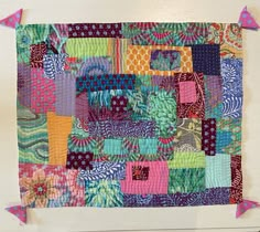 a colorful patchwork quilt hanging on a wall