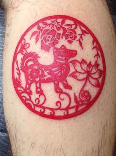 a man with a red tattoo on his arm has a dog and flowers in the center