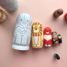 an assortment of wooden toys sitting on top of a pink surface next to each other