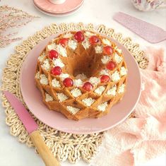 a cake on a pink plate sitting on a doily