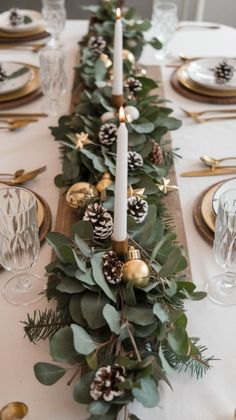 the table is set with pine cones, greenery and candles