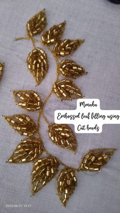 some gold colored leaves on a white table cloth with text overlay that reads monker embossed leaf - filling using cat beads