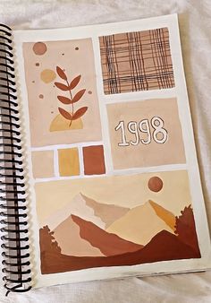 a spiral notebook with an image of mountains and trees on the cover is open to show numbers