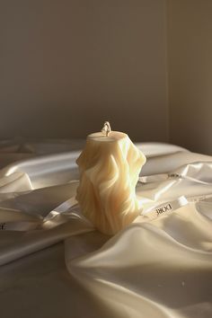 a candle that is sitting on some white sheets