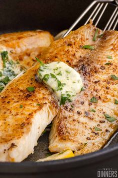 the fish is being cooked in the skillet with butter and parsley on top