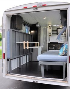 the inside of a moving truck with its door open to reveal a bed and storage area